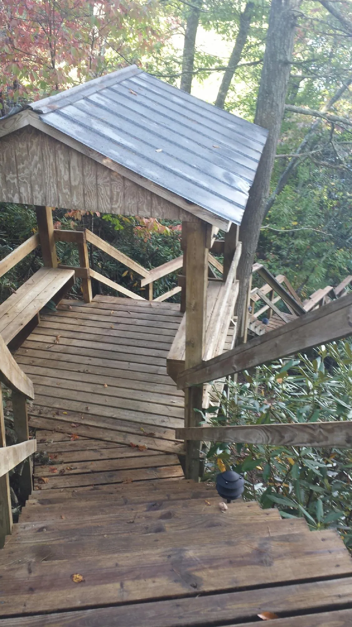 Metal roofed shelter over wooden steps on a wooded walkway — Skylight Repair & Installation work by our crew in Hughson