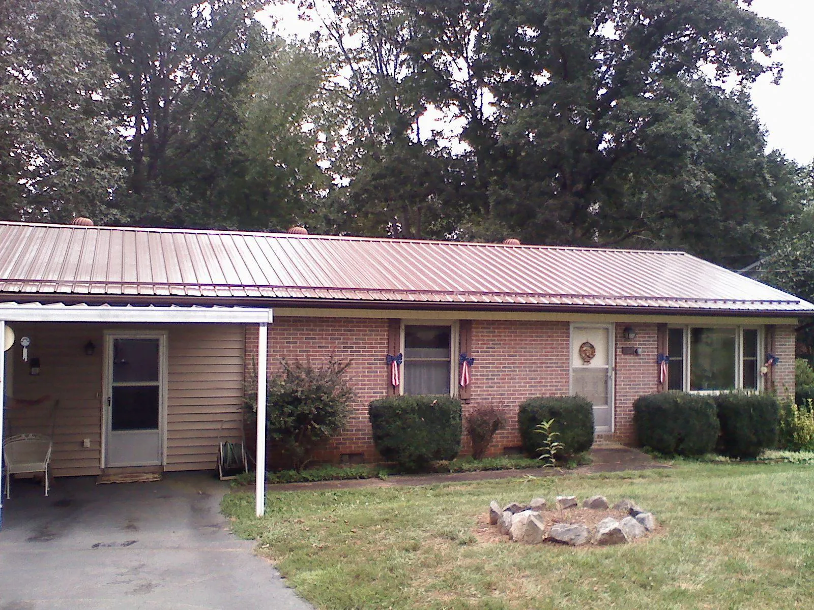 Bronze metal roof and carport on a brick ranch home — Roof Repair work by our crew in Hughson